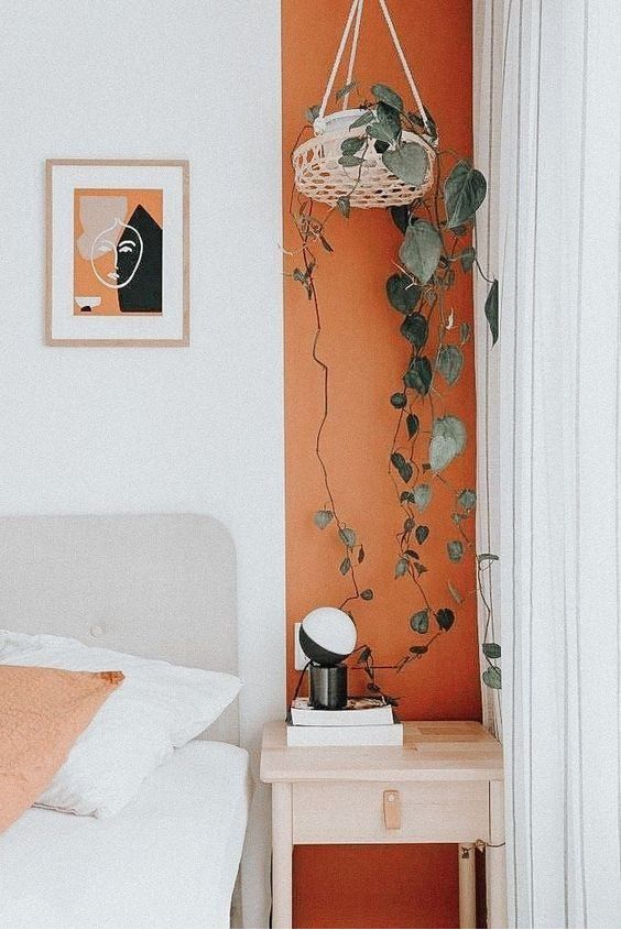 Dormitorio sutil com parede e tecidos brancos com um detalhe de pintura vertical alinhada a mesa ...