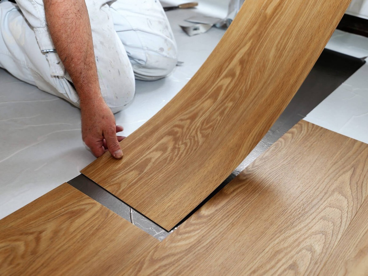 régua de piso vinílico sendo instalada mostrando sua flexibilidade ao encaixar ela no vao