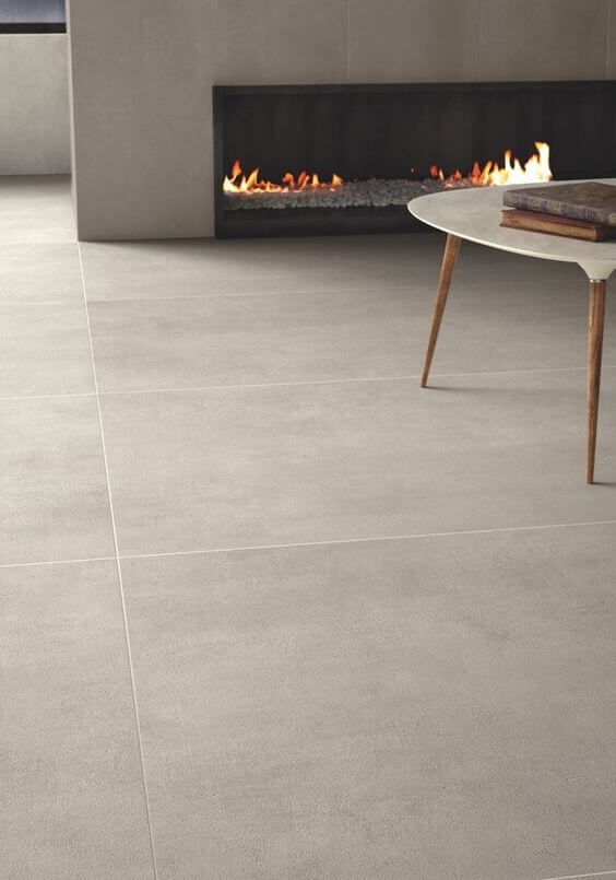 Sala com lareira e piso em porcelanato peças grandes cinza claro imitando um concreto branco